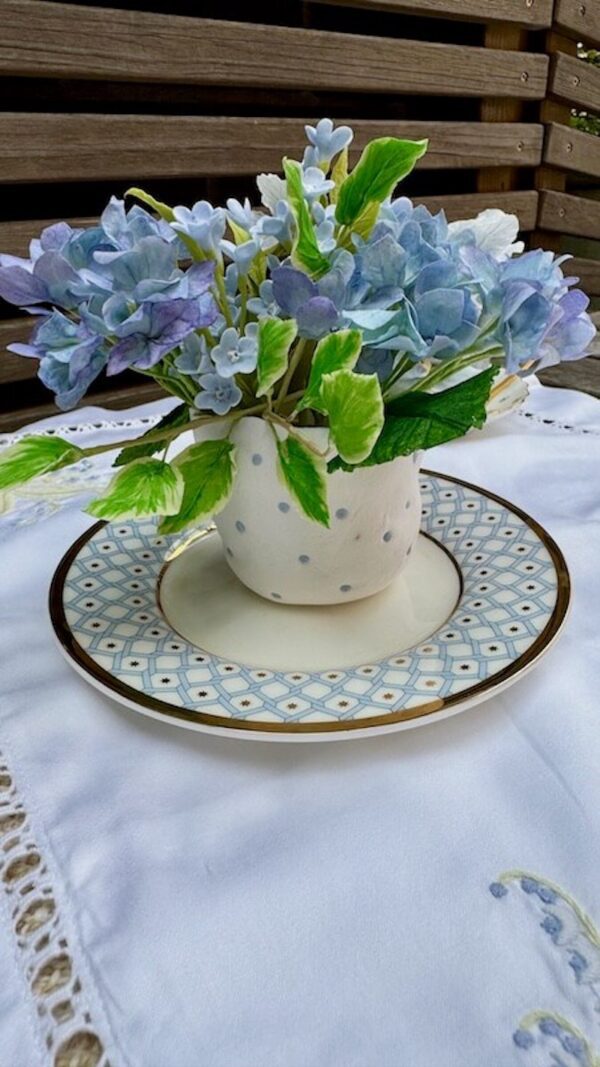 blue hydrangea bouquet in white clay pot